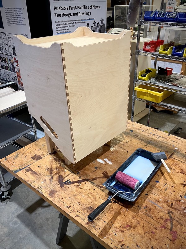 Box next to paint tray, roller, and foam brush for finishing with clear coat.