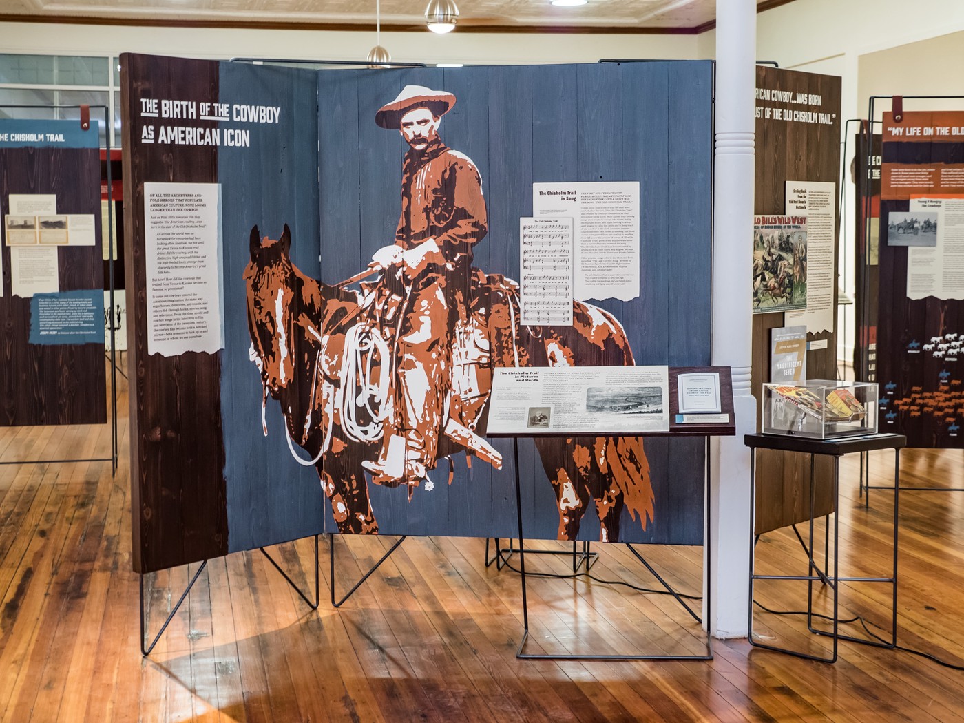 The Birth of the Cowboy as American Icon interpretive panel featuring large stenciled image of cowboy on horse