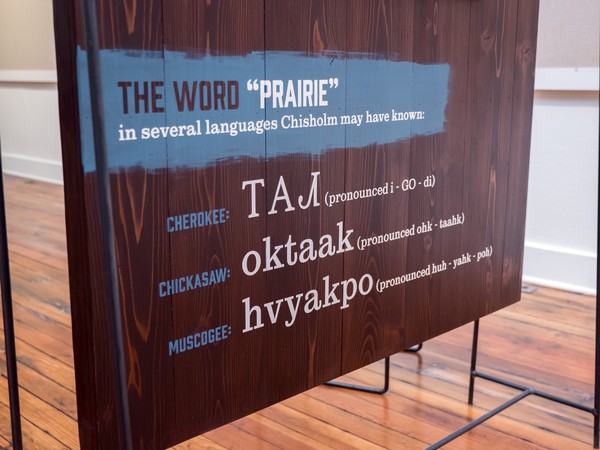 stenciled text of the word prairie in several languages: Cherokee, Chickasaw, and Muscogee