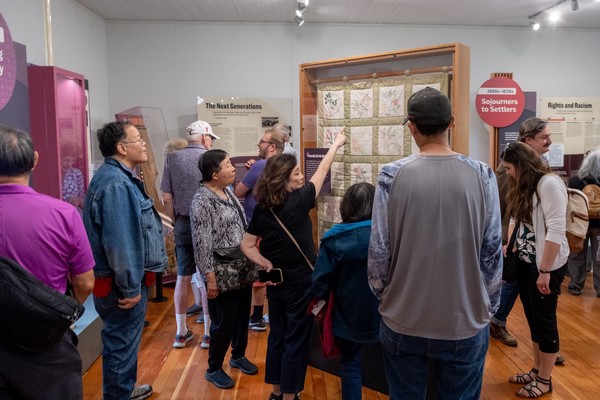 A woman points to a quilt on display