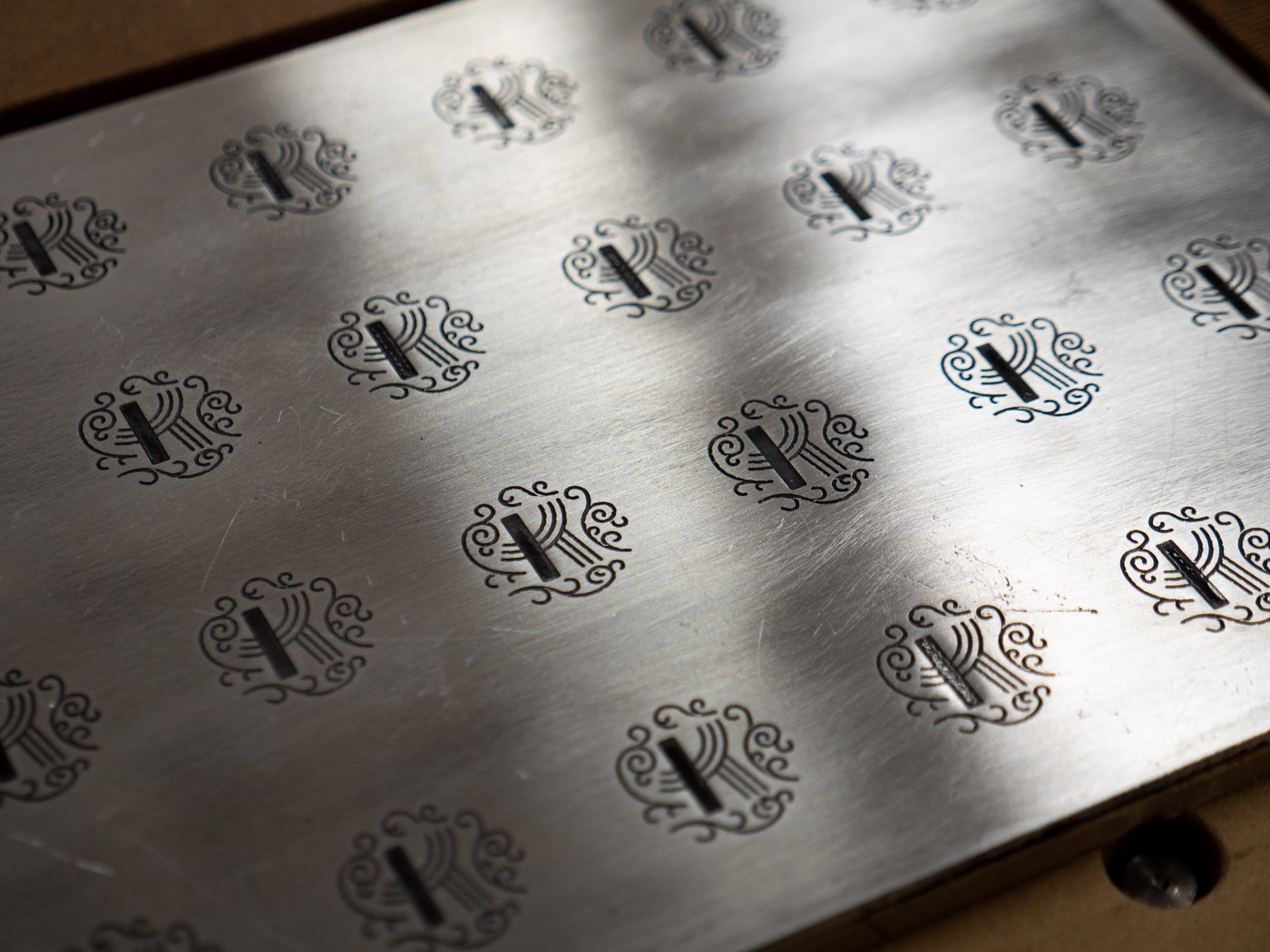 a grid of the enamel-filled engravings on a shiny aluminum plate