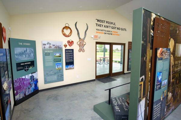 Metal sculptures and interpretive panels on South wall. Large Liggett quote on wall: Most people they ain't got not guts. You gotta have a strong opinion or you're nothing.