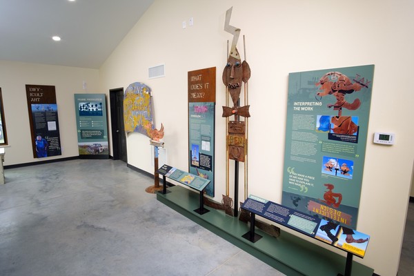 Interpretive panels along a wall with a relatively small totem sculpture 'BEN'